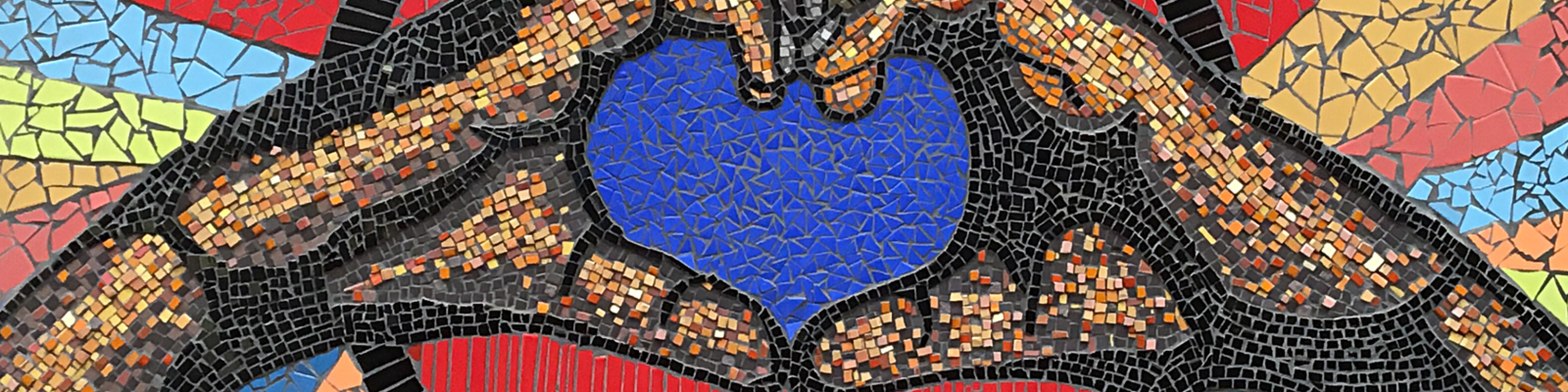 Close-up of a mosaic depicting hands formed into a heart shape.