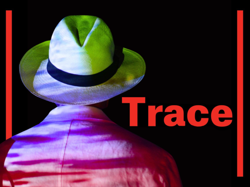 promotional poster for Trace features a photo of Tristan, wearing a white jacket and fedora, standing with his back to the camera. Colourful light is projected onto his back.