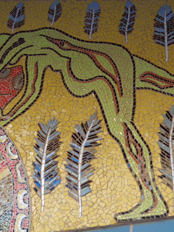 Close-up of a mosaic depicting a human form amongst a collection of feathers.