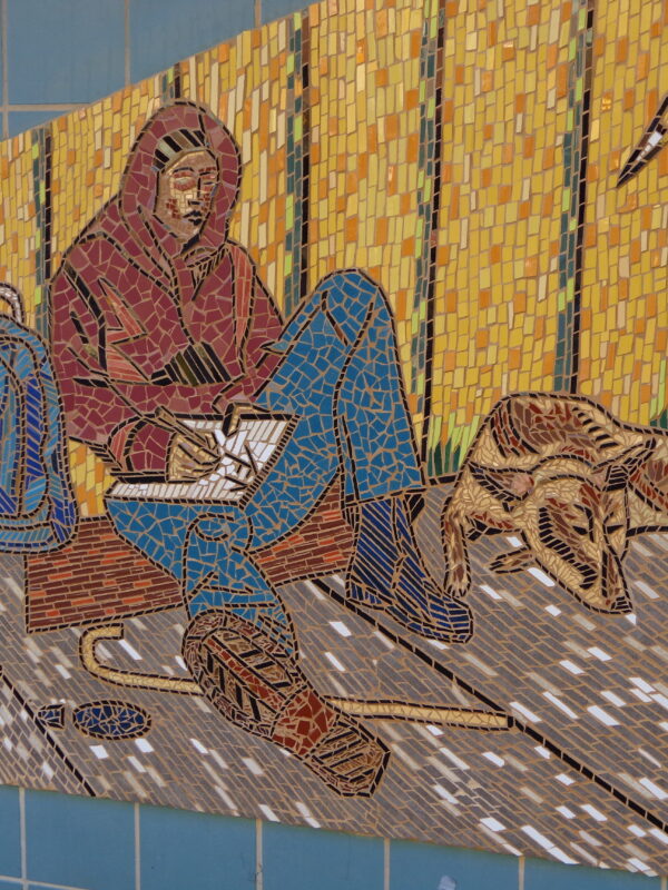 Mosaic depicting a person and dog, sitting on the sidewalk with a backpack, notebook, and walking cane.