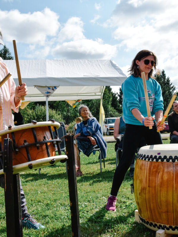 Close-up of two participants drumming during a workshop.