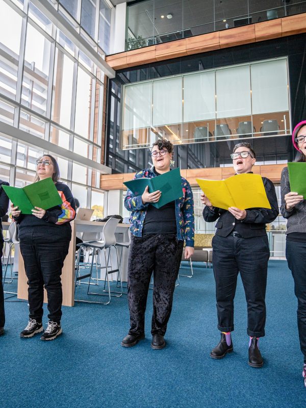 A choir section stands together singing out to the audience.