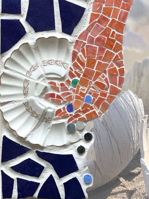 A digital collage features (left to right) a ceramic and glass mosaic by Wy Joung Kou and an installation of hand-made vessels by Anna Camilleri. The mosaic features an orange hand opening to release small, multicoloured, marble sized round objects, against a backdrop of a fragmented white tea saucer surrounded by navy blue fragments. Many round white-grey vessels, installed on a sandy beach, have smooth interiors, textured exteriors and uneven edges. The vessels in the foreground are in sharp focus, with seemingly endless vessels extending out into the blurry distance.