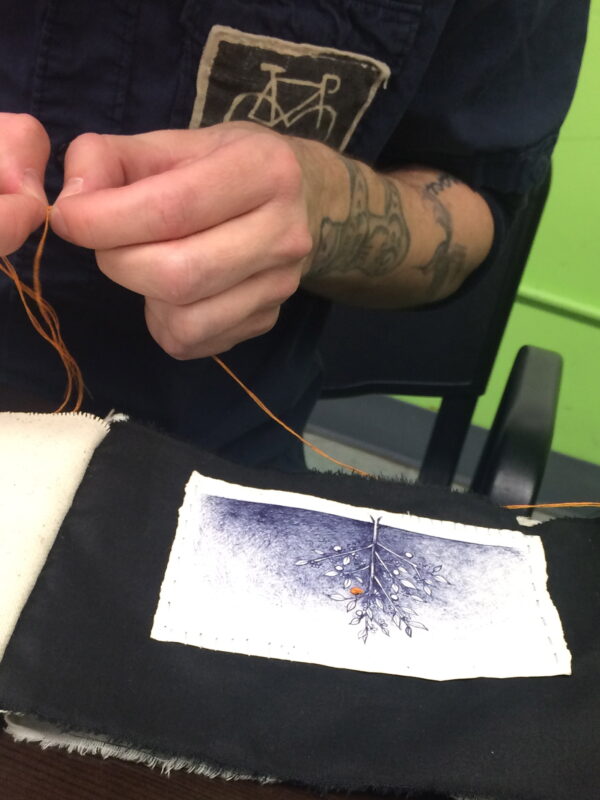 Close-up of hands embroidering fabric.